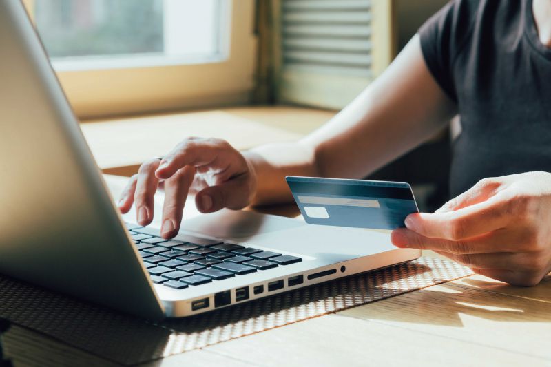 Image of user on laptop adding the credit card to online website